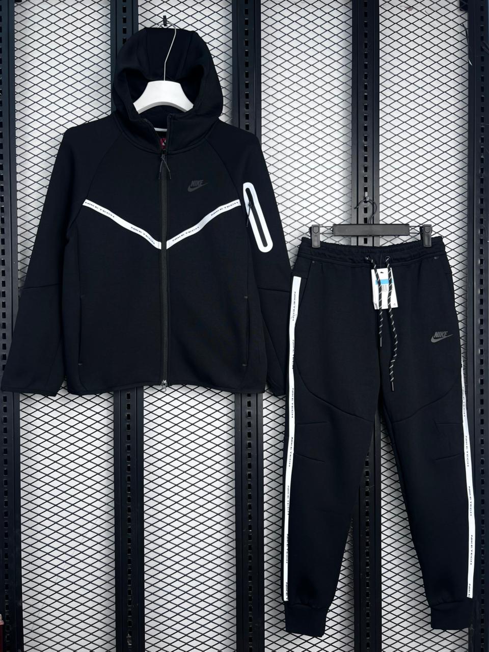 Black tracksuit with white accents on a textured black background
